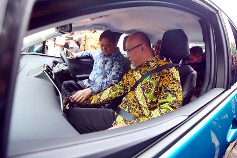 Presiden Direktur TMMIN Warih Andang Tjahjono (kanan) didampingi Airlangga Hartarto (Menteri Perindustrian Kabinet Kerja) saat mencoba mobil listrik