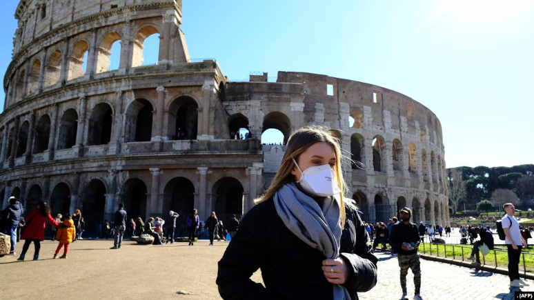 Para turis mengenakan masker saat mengunjungi Coliseum di Roma, Italia (foto: ilustrasi).