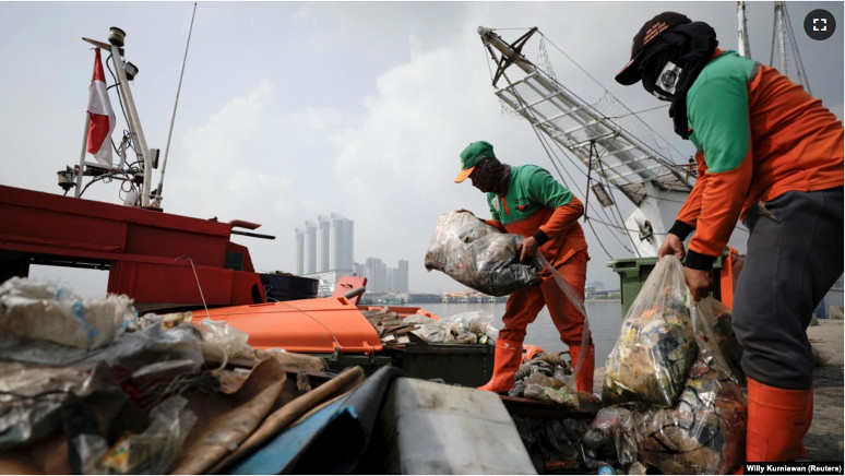Sejumlah petugas kebersihan pemda membersihkan sampah dari pinggir pantai di Pelabuhan Kali Adem, Jakarta, 8 Juni 2021. (Foto: Willy Kurniawan/Reuters)