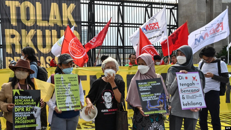 Aktivis melakukan demonstrasi menentang pengesahkan KUHP di luar gedung parlemen di Jakarta. (Foto: AFP/Adek Berry)