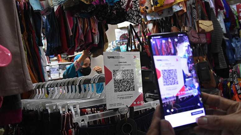 Pembeli bertransaksi nontunai melalui QRIS di Pasar Santa, Jakarta, Senin 6 Desember 2021. (ANTARA FOTO/Indrianto Eko Suwarso).