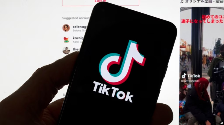 Logo TikTok terlihat di ponsel di depan layar komputer, 18 Maret 2023 di Boston. (Foto: AP)