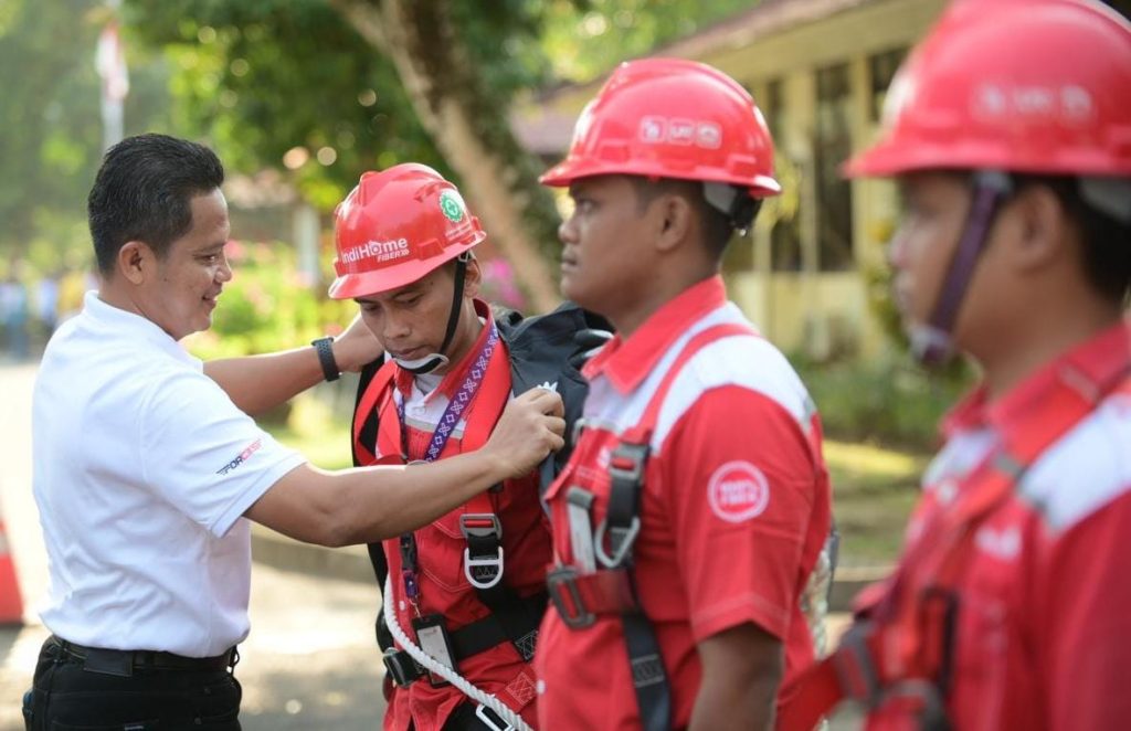 Ketua Satgas KTT AIS Forum 2023 TelkomGroup, Syaifudin secara simbolis menyematkan perlengkapan kerja kepada perwakilan teknisi lapangan yang bertugas dalam pengawalan infrastruktur, jaringan, dan layanan TelkomGroup selama penyelenggaraan KTT, Nusa Dua Bali (6/10).